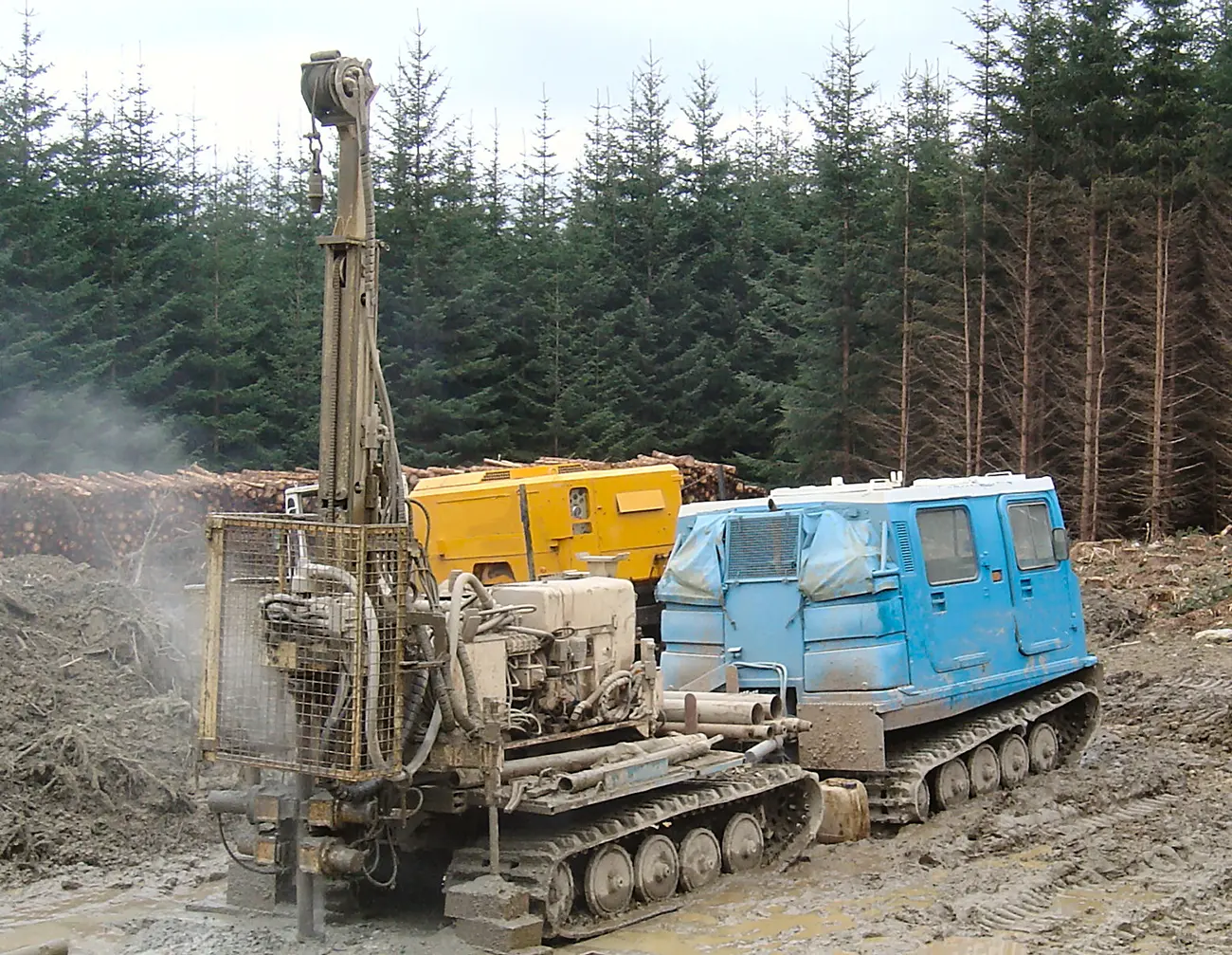 rotary borehole drill at work in woodland